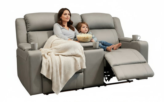Woman and child sitting on a gray recliner with popcorn, blanket, and cups.