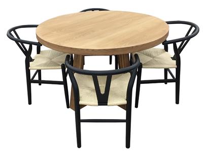 Round wooden table with four matching black wishbone chairs